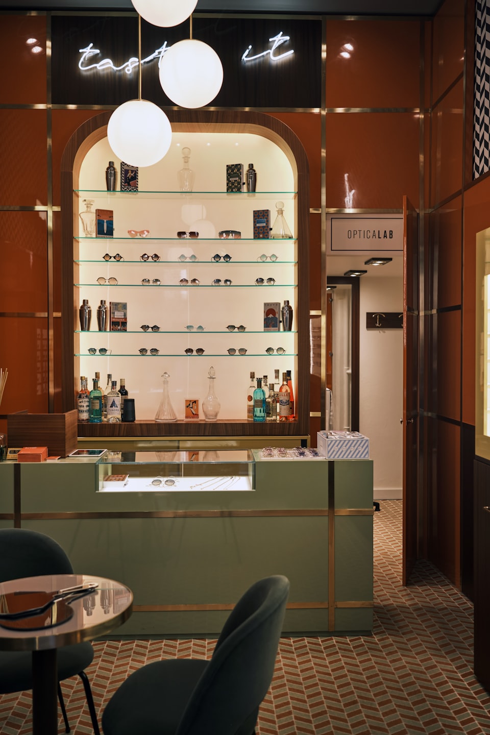 Optical boutique interior with shelves of glasses and pendant lights.