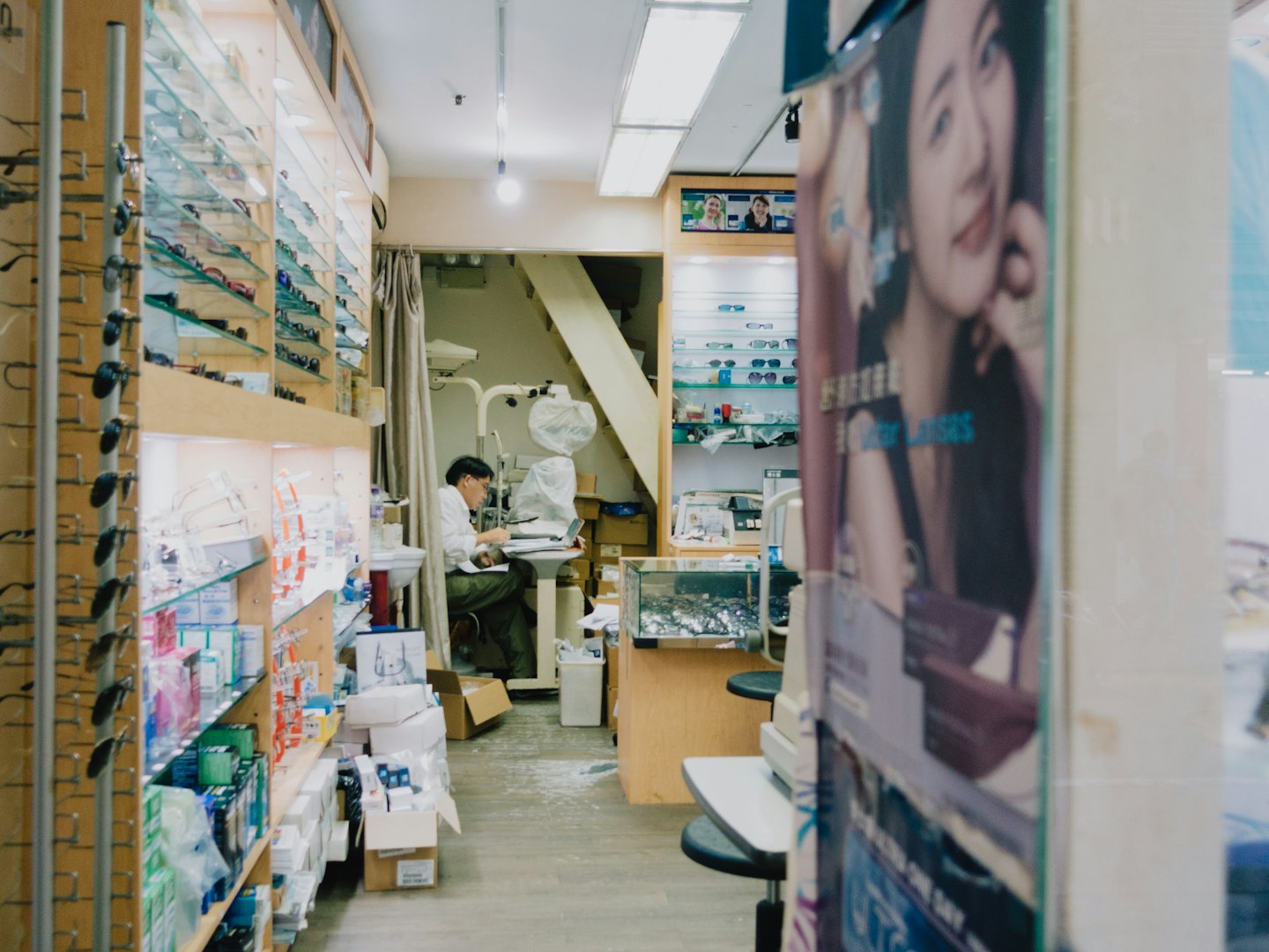 Optician works at a desk in an optical shop.